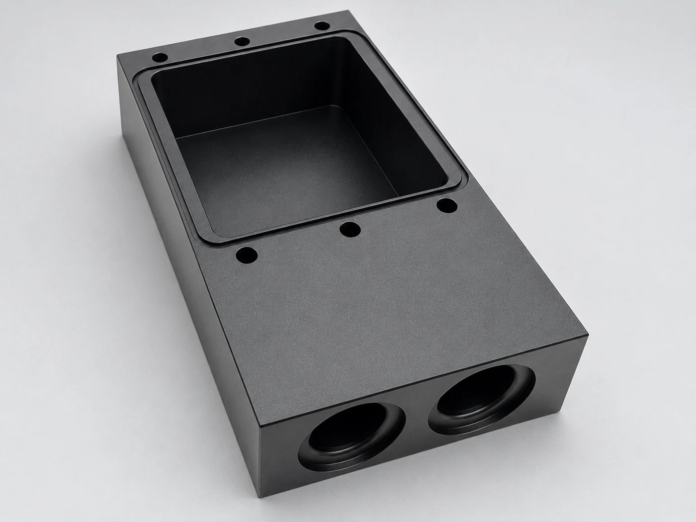 Machined housing with a top cavity and front ports